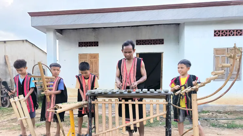 A Ngự dạy thanh thiếu niên trong xã biểu diễn nhạc cụ dân tộc. Ảnh: HP