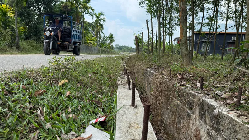 Tuyến đường bê tông nông thôn xã Tam Xuân 2 (huyện Núi Thành, tỉnh Quảng Nam) thi công dở dang để lộ dãy cọc sắt gây nguy hiểm cho người tham gia giao thông. 