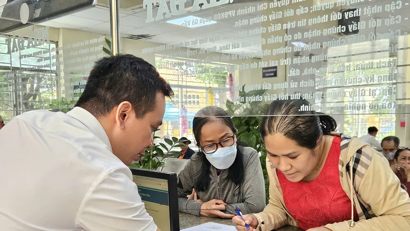 Ông Trương Văn Sự, thành viên tổ địa bàn tại Trung tâm Phục vụ hành chính công phường Gò Vấp, TPHCM hướng dẫn người dân thực hiện thủ tục hành chính. Ảnh: NGÔ BÌNH