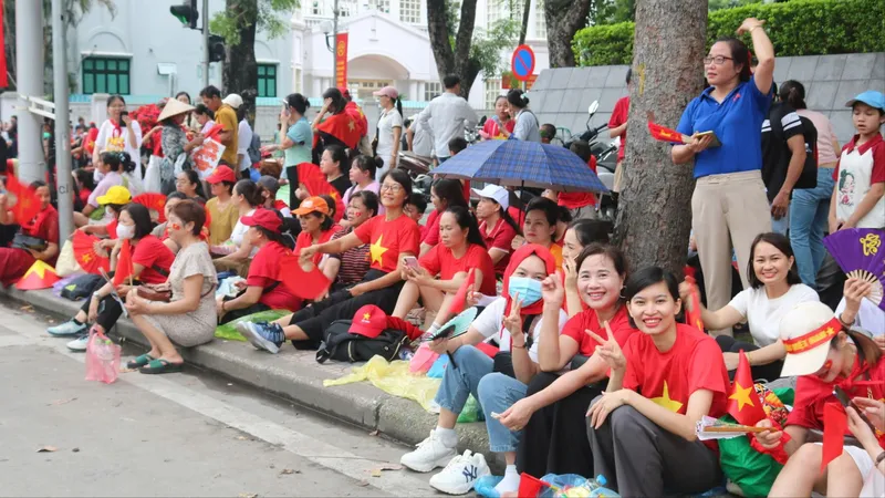 Bà cụ dù khuyết tật thể vận động nhưng vẫn hòa cùng vào dòng người xem hợp luyện. Ảnh HÀ NGUYỄN