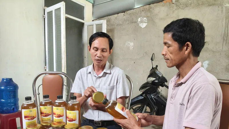 Ông Nguyễn Hồng Châu (bên phải) thuyết minh về sản phẩm mật ong do người dân sản xuất