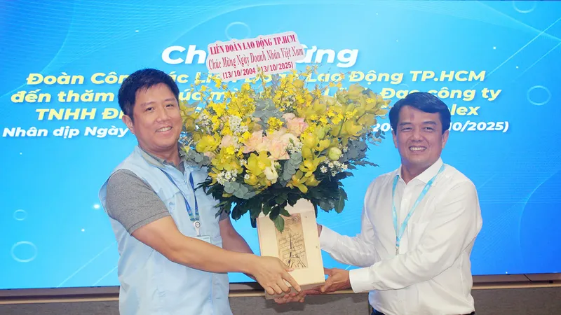 Đồng chí Bùi Thanh Nhân (bìa phải) tặng hoa đến đại diện lãnh đạo Công ty TNHH Điện tử Samsung HCMC CE Complex 