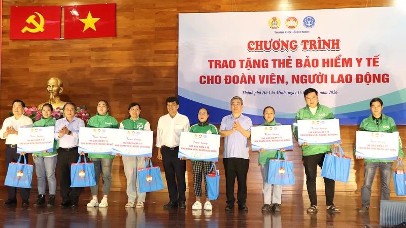 Phó Bí thư Thành ủy TPHCM Nguyễn Phước Lộc (giữa) trao thẻ BHYT và quà đến người lao động khó khăn