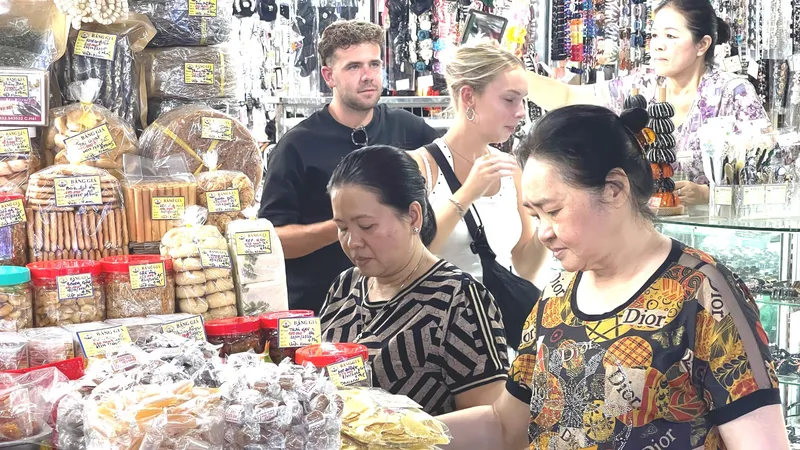 Người dân và du khách mua sắm các mặt hàng đặc sản, quà lưu niệm tại chợ Bến Thành. Ảnh: HOÀNG HÙNG
