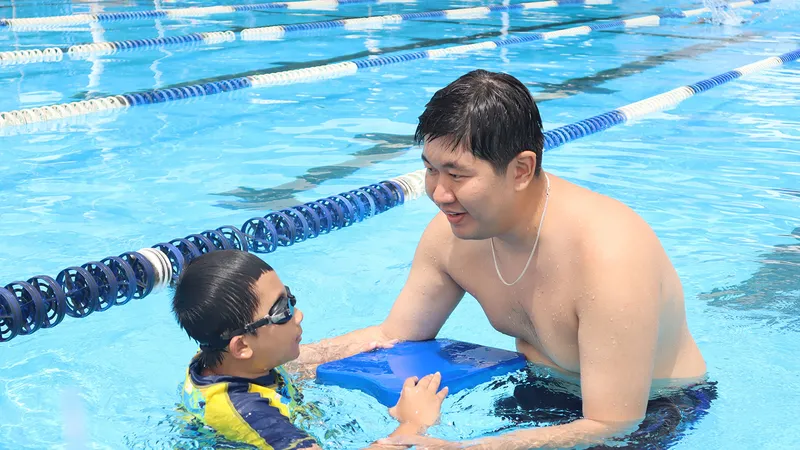 Huấn luyện viên hướng dẫn trẻ em tập bơi tại Trung tâm Thể thao dưới nước TPHCM. Ảnh: DŨNG PHƯƠNG