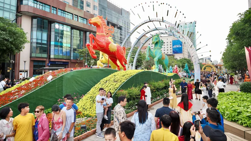 Đoàn khách quốc tế tham quan đường hoa, chiều 21-2. Ảnh: HOÀNG HÙNG