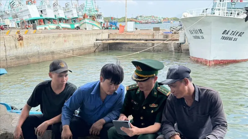Lực lượng Biên phòng TPHCM hướng dẫn ngư dân truy cập thông tin bầu cử qua ứng dụng trên điện thoại thông minh. Ảnh: TRÚC GIANG