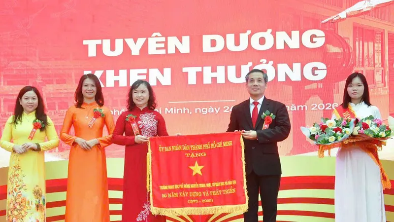 Ông Nguyễn Kế Toại, Phó Giám đốc Sở GD-ĐT TPHCM, trao cờ thi đua của UBND TPHCM tặng Trường THPT Nguyễn Trung Trực