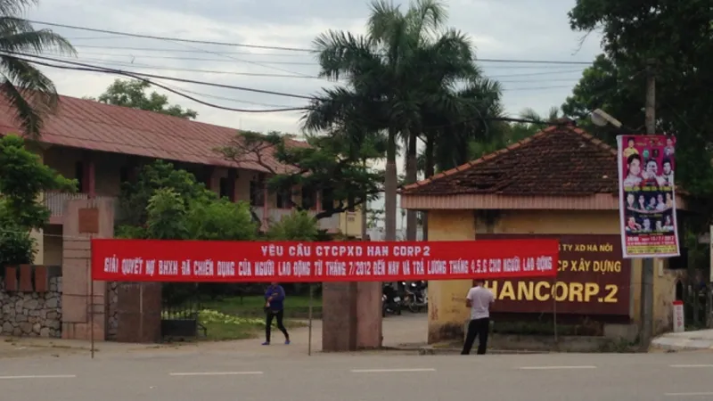 Công nhân căng băng rôn trước trụ sở công ty để đòi tiền lương