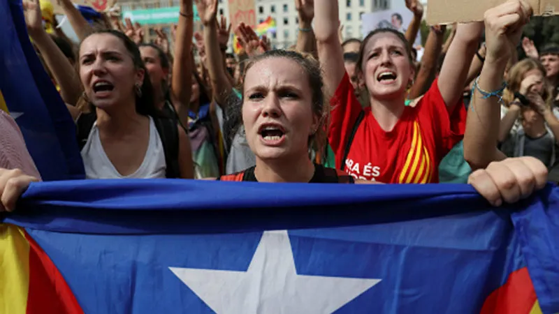Một phụ nữ cầm cờ ly khai của Catalonia trên đường phố Barcelona hôm 2/10. Ảnh: Reuters.