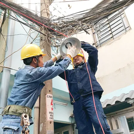 Đoàn viên thanh niên ngành điện thi công lắp mới đèn chiếu sáng tuyến hẻm
