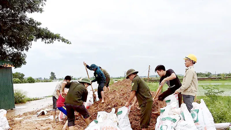 Bộ đội cùng người dân huyện Quốc Oai (Hà Nội) chung sức đắp đê bao ngăn nước lũ sông Tích tràn vào khu dân cư ngày 22-7