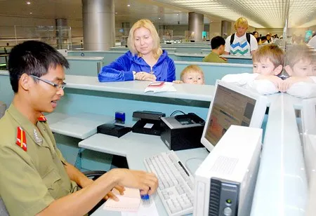 Sĩ quan an ninh cửa khẩu sân bay Tân Sơn Nhất làm thủ tục xuất nhập cảnh cho hành khách. Ảnh: CAO THĂNG