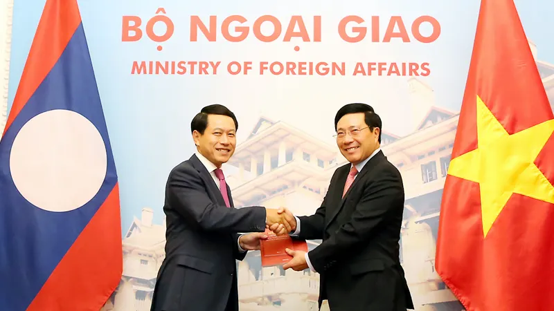 Phó Thủ tướng Phạm Bình Minh và Bộ trưởng Ngoại giao Lào Saleumxay Kommasith trao đổi Nghị định thư về đường biên giới và mốc quốc giới Việt Nam-Lào và Hiệp định về Quy chế quản lý biên giới và cửa khẩu biên giới Việt Nam-Lào. Ảnh: VGP