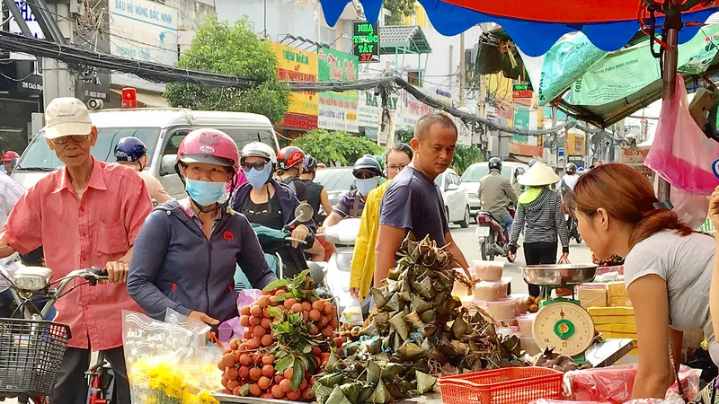 Khách hàng chọn mua bánh ú, trái cây sát chợ Hòa Hưng, quận 10, TPHCM, sáng 18-6. Ảnh: THI HỒNG