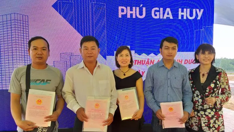 Lãnh đạo công ty trao sổ đỏ cho khách hàng