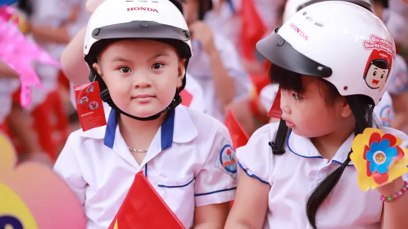 Niềm vui của các em nhỏ nhân khi nhận được mũ bảo hiểm nhân ngày khai giảng 