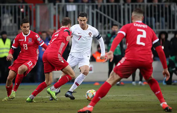 Ronaldo (áo trắng) đi bóng trước hàng phòng ngự Luxembourg
