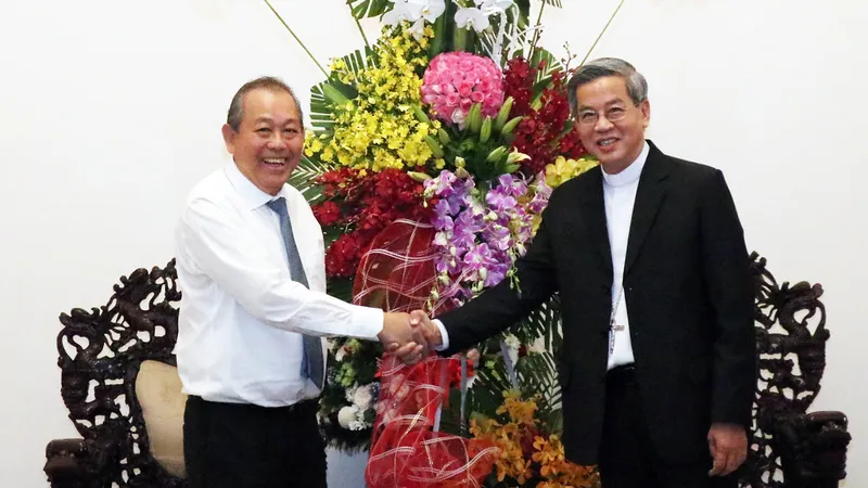 Phó Thủ tướng Thường trực Trương Hòa Bình trao lẵng hoa của Tổng Bí thư, Chủ tịch nước Nguyễn Phú Trọng chúc mừng Tổng Giám mục Giuse Nguyễn Năng. Ảnh: TTXVN
