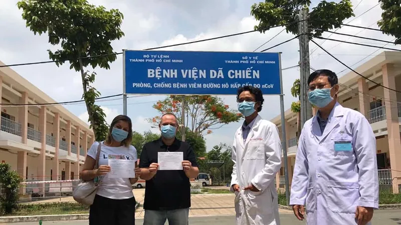 Hai bệnh nhân được điều trị khỏi Covid-19 xuất viện tại Bệnh viện bệnh lý hô hấp cấp tính Củ Chi trong sáng 18-4. Ảnh: TTXVN