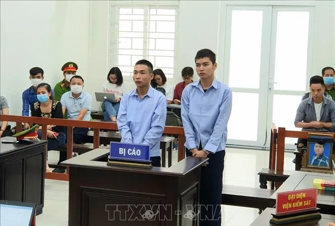 Bị cáo Đinh Văn Giáp (trái) và bị cáo Đinh Văn Trường tại phiên xét xử. Ảnh: TTXVN
