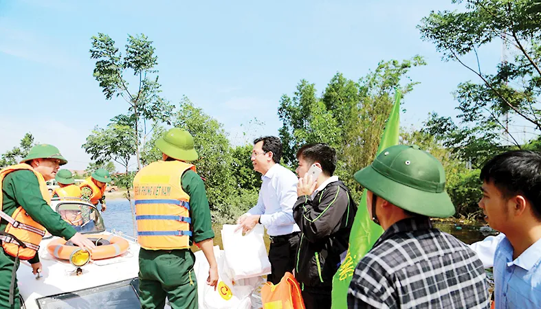 Anh Vũ Anh Tuấn (người mặc áo trắng) Phó TGĐ CPV cùng đoàn công tác của Bộ trưởng Bộ NN-PTNT trao tặng 100 suất quà tại vùng lũ huyện Lệ Thủy, tỉnh Quảng Bình