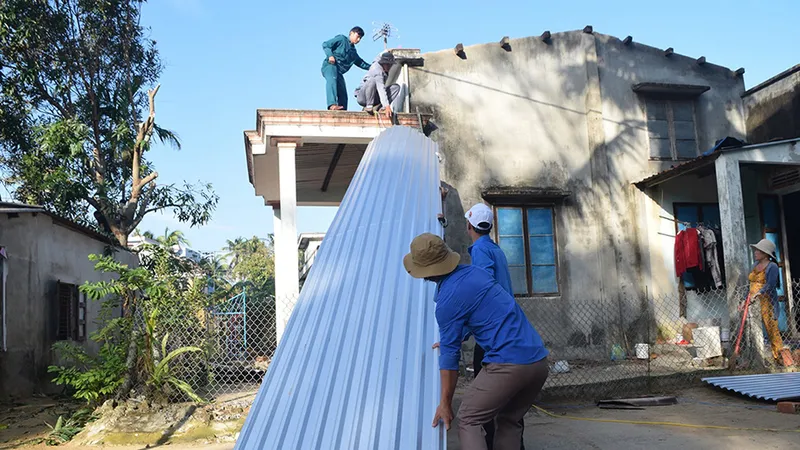 Các bạn trẻ hỗ trợ người dân lợp lại nhà sau bão số 9