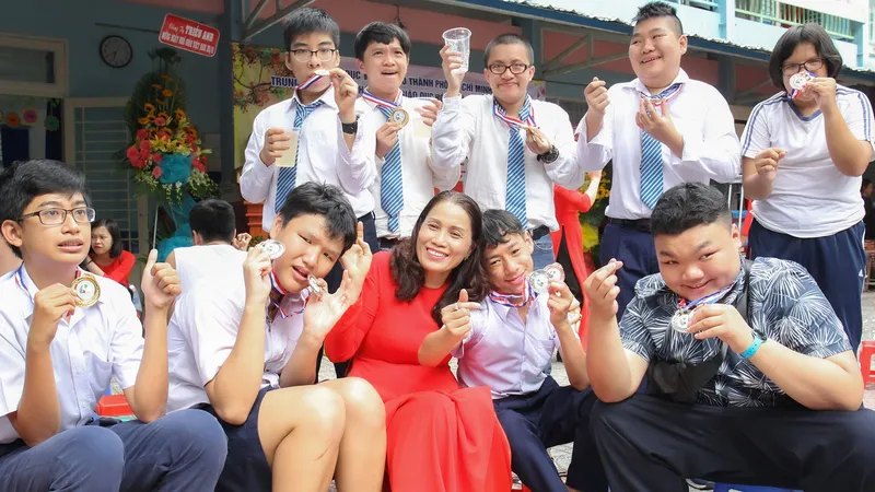 Cô Lê Thị Kim Chi, Giám đốc Trung tâm Hỗ trợ phát triển giáo dục hòa nhập Tân Bình (quận Tân Bình) cùng các học trò của mình. Ảnh: HOÀNG HÙNG