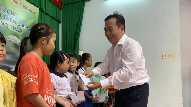 Ông Đỗ Minh Khương, đại diện Ngân hàng Agribank - Văn phòng đại diện Tây Nam bộ trao học bổng cho học sinh. Ảnh: H.D
