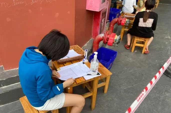 Khách hàng được bố trí ngồi giãn cách bên ngoài để nhân viên siêu thị giúp chọn hàng theo yêu cầu tại Co.opmart Tô Ký (quận 12). Ảnh: NLĐ