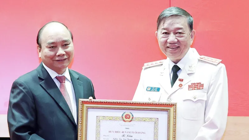 Chủ tịch nước Nguyễn Xuân Phúc trao tặng Huy hiệu 40 năm tuổi Đảng cho Đại tướng Tô Lâm, Bộ trưởng Bộ Công an. Ảnh: TTXVN