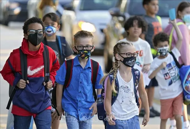 Các em nhỏ đeo khẩu trang phòng dịch Covid-19 khi ngày đầu tiên trở lại trường học sau thời gian dài giãn cách, tại Riverview, bang Florida (Mỹ) ngày 10-8-2021. Ảnh minh họa: AP/TTXVN