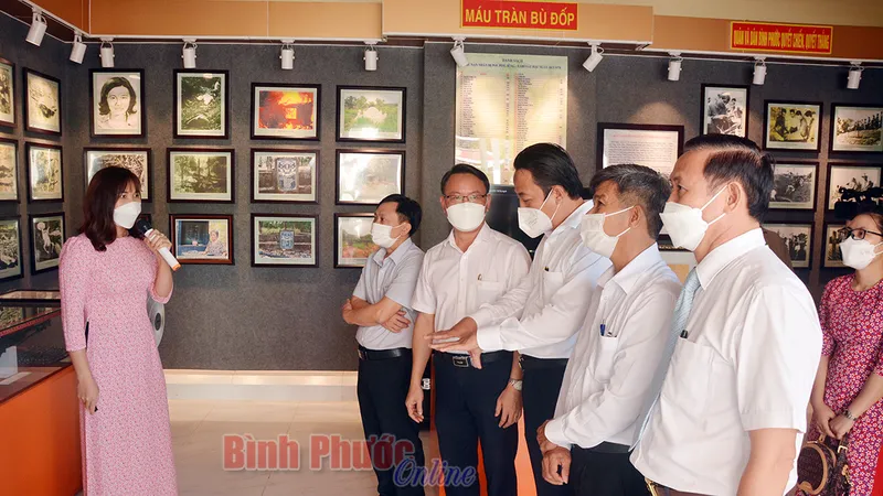Các đại biểu nghe hướng dẫn viên thuyết minh về di tích. Ảnh: Báo Bình Phước