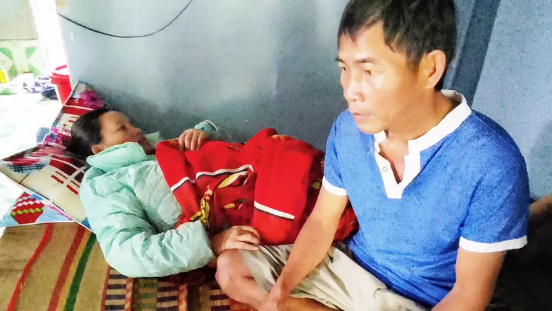 Anh Ngô Văn Kiểm bên người vợ nằm liệt giường suốt 11 năm qua