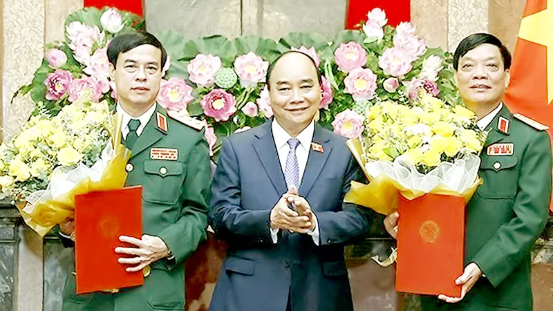 Chủ tịch nước Nguyễn Xuân Phúc, Thống lĩnh các lực lượng vũ trang nhân dân, Chủ tịch Hội đồng Quốc phòng và An ninh, trao Quyết định thăng quân hàm từ Trung tướng lên Thượng tướng đối với đồng chí Ngô Minh Tiến và Lương Đình Hồng. Ảnh: TTXVN