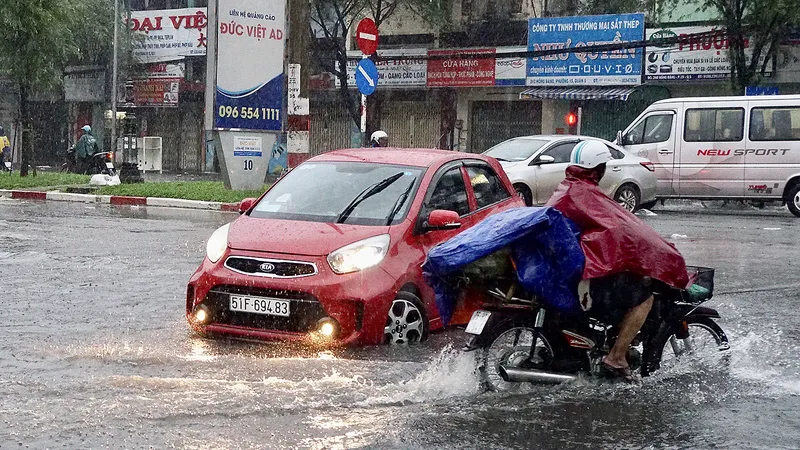 Mưa lớn, triều cường làm ngập đường, gây khó khăn cho sinh hoạt của người dân