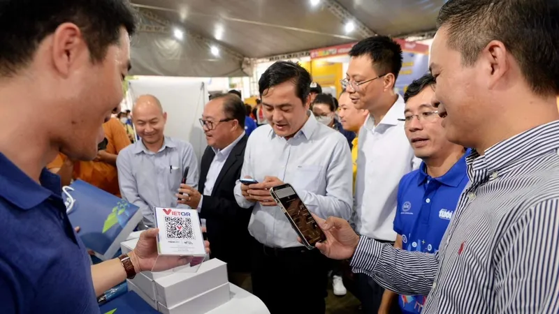 Ông Bùi Tá Hoàng Vũ và du khách tham gia trải nghiệm các phương thức thanh toán không tiền mặt tại quận 7 