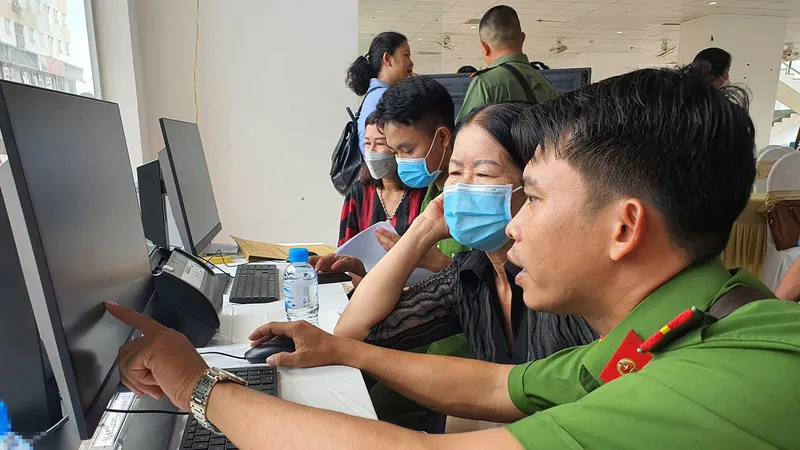 Một cán bộ công an hướng dẫn người dân làm thủ tục. Ảnh minh họa: NGÔ BÌNH 