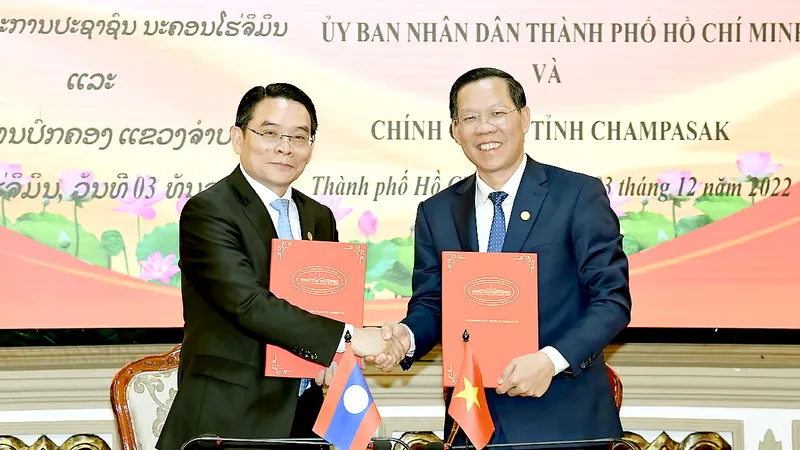 Trao đổi Bản ghi nhớ hợp tác giữa UBND TPHCM và chính quyền tỉnh Champasak. Ảnh: VIỆT DŨNG