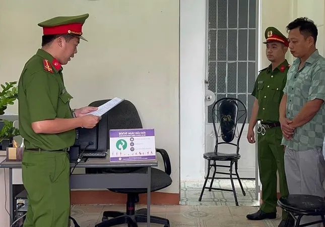 Công an huyện Khánh Vĩnh đọc lệnh khởi tố bị can đối với Trần Thiện Sinh. Ảnh T.T.