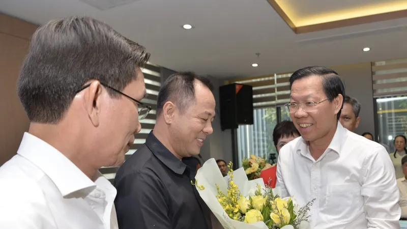 Chủ tịch UBND TPHCM Phan Văn Mãi tặng hoa chúc mừng các Chủ tịch hội đồng hiệu trưởng khối ngành. Ảnh: CAO THĂNG