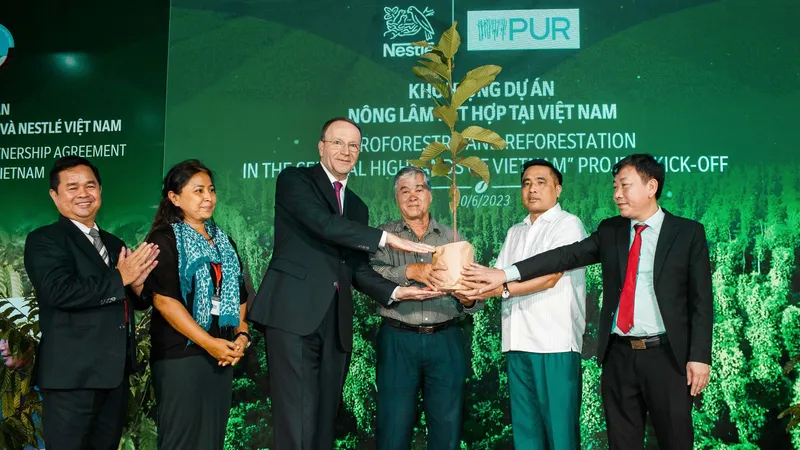 Ông Mark Schneider, Giám đốc điều hành Tập đoàn Nestlé (thứ 3 từ trái sang) trao cây đến người nông dân (thứ 4 từ trái sang), khởi động dự án nông lâm kết hợp tại Việt Nam