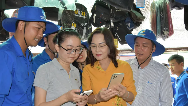 Phó Bí thư Thường trực Tỉnh ủy Bạc Liêu Lê Thị Ái Nam (thứ ba, từ trái sang) trải nghiệm mua sắm thanh toán không dùng tiền mặt tại chợ Hộ Phòng, thị xã Giá Rai
