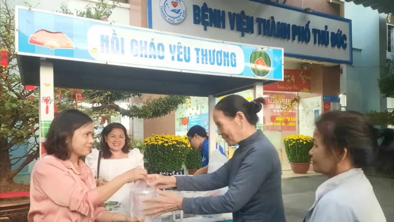 Nhân viên bệnh viện và mạnh thường quân trao những hộp cháo đến bệnh nhân và thân nhân người bệnh