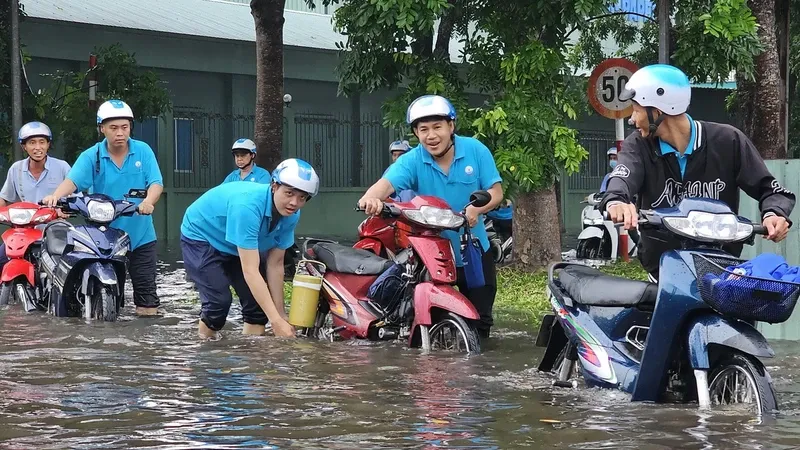 Nhiều công nhân lội nước đi làm tại Khu công nghiệp Giao Long. Ảnh: TTXVN