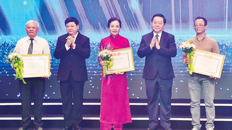 Trưởng Ban Tuyên giáo Trung ương Nguyễn Trọng Nghĩa trao giải cho các tác giả nhận tặng thưởng mức B. Ảnh: TTXVN