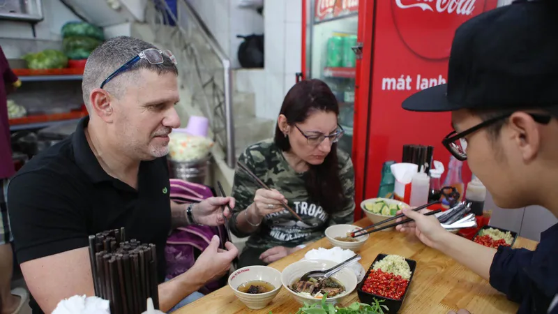 Du khách nước ngoài thưởng thức bún chả Việt Nam. Ảnh: HOÀNG TRIỀU