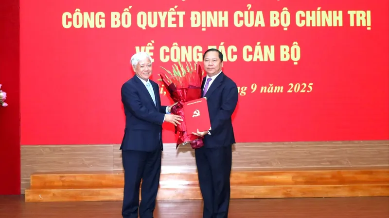 Đồng chí Đỗ Văn Chiến, Bí thư Đảng ủy MTTQ, các đoàn thể Trung ương (trái) trao Quyết định cho đồng chí Nguyễn Phi Long
