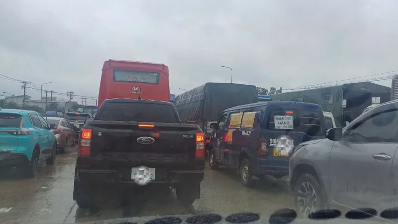 Quốc lộ 1K ùn ứ kéo dài, người dân chật vật di chuyển trong mưa