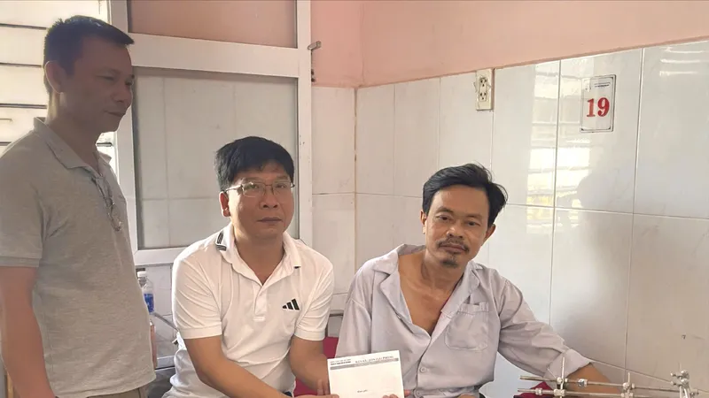 Đại diện Báo SGGP trao tiền cho anh Lê Văn Toán